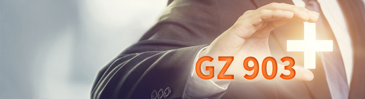 Ein Plus-Zeichen und das Wort "GZ 903" vor dem ausgestreckten Finger eines Mannes mit Anzug im Hintergrund.